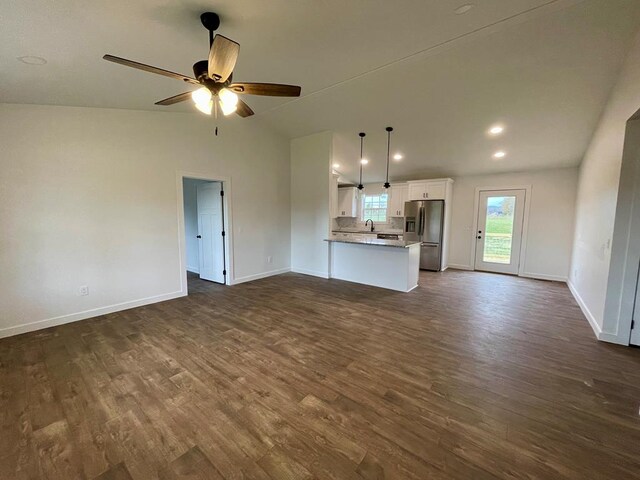 unfurnished living room with dark wood-style flooring, vaulted ceiling, baseboards, and ceiling fan