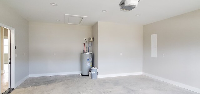 garage featuring baseboards, a garage door opener, and electric water heater