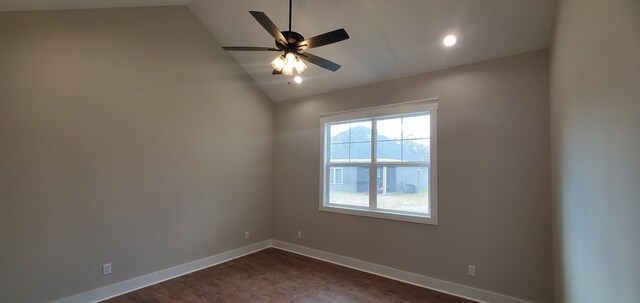 empty room with a ceiling fan, lofted ceiling, dark wood-style flooring, and baseboards