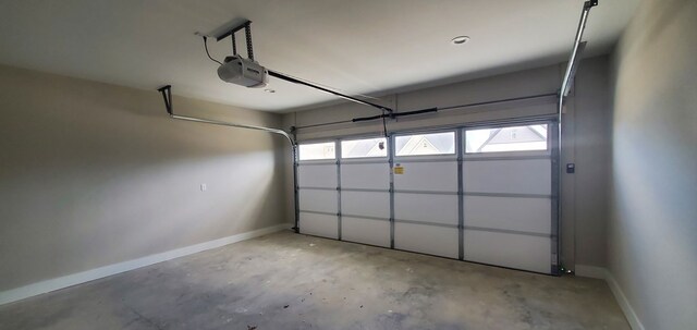 garage featuring a garage door opener and baseboards