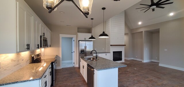 kitchen with a kitchen island with sink, stainless steel appliances, a sink, white cabinetry, and hanging light fixtures