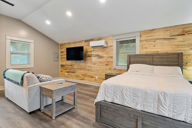 bedroom featuring wood finished floors, multiple windows, wood walls, and a wall mounted AC