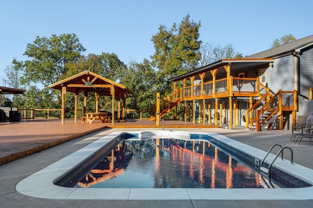 outdoor pool featuring a patio, stairway, and a wooden deck