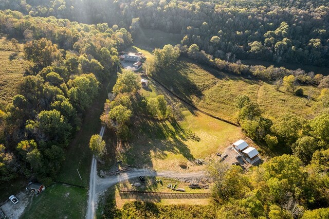 birds eye view of property featuring a wooded view and a rural view