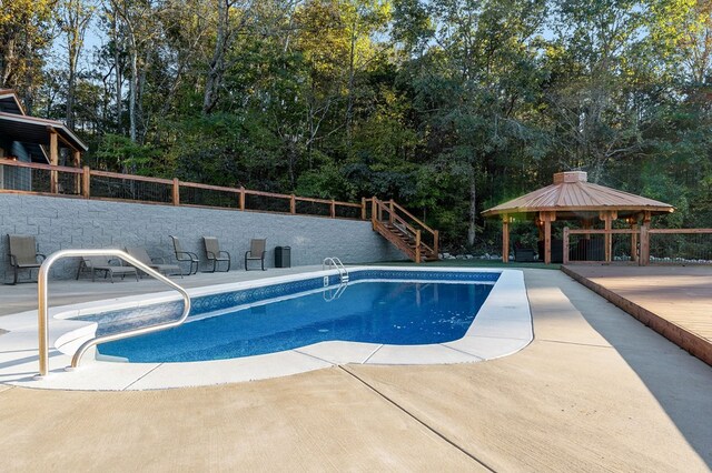 view of pool with fence and a gazebo