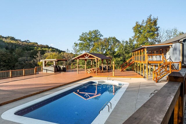 view of pool featuring a fenced in pool, a deck, and a gazebo