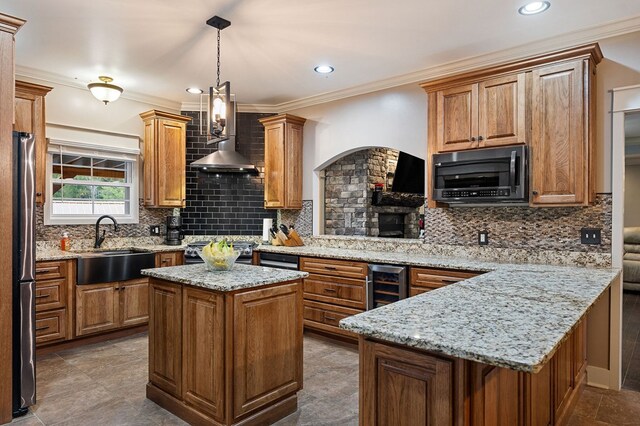 kitchen featuring light stone counters, freestanding refrigerator, a sink, and black range oven