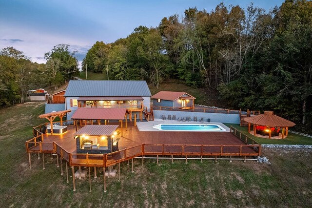 view of pool featuring a fenced in pool, a yard, a deck, and a gazebo