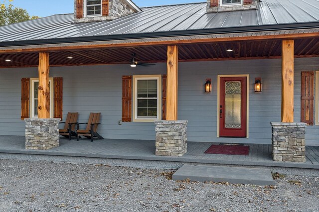 entrance to property with a standing seam roof, metal roof, and covered porch