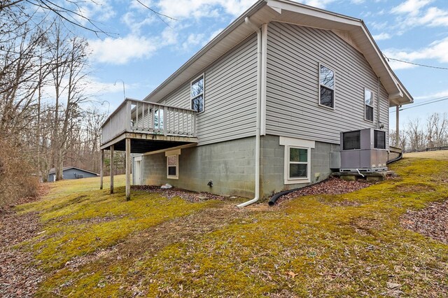 view of side of home with a wooden deck and a yard