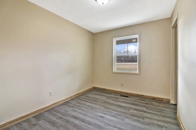 empty room featuring baseboards and wood finished floors