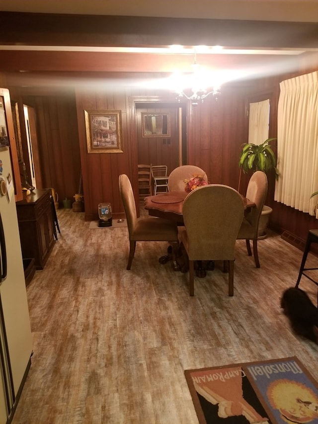 dining space featuring wooden walls and wood finished floors