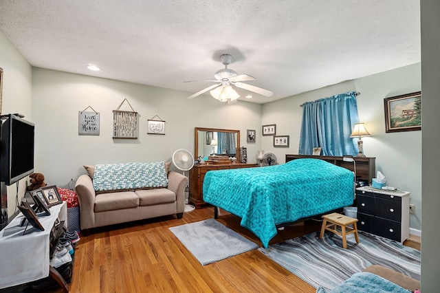 bedroom with a textured ceiling, a ceiling fan, wood finished floors, and recessed lighting