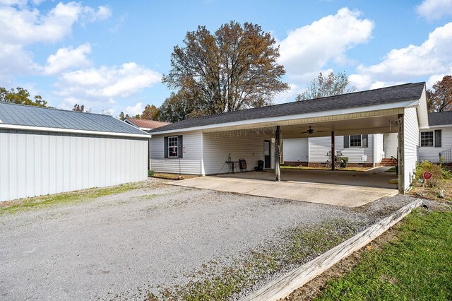 rear view of property featuring an attached carport and gravel driveway