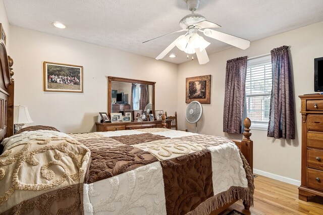 bedroom featuring light wood finished floors, baseboards, a ceiling fan, a textured ceiling, and recessed lighting