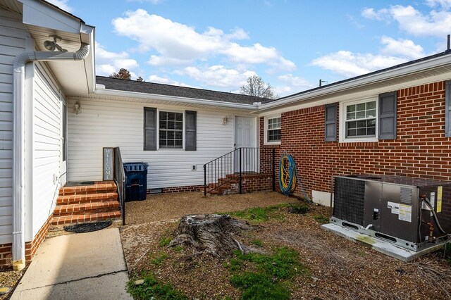 doorway to property with crawl space, central AC, and brick siding