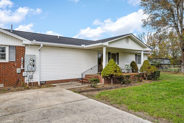 ranch-style home featuring crawl space, roof with shingles, a porch, and a front yard