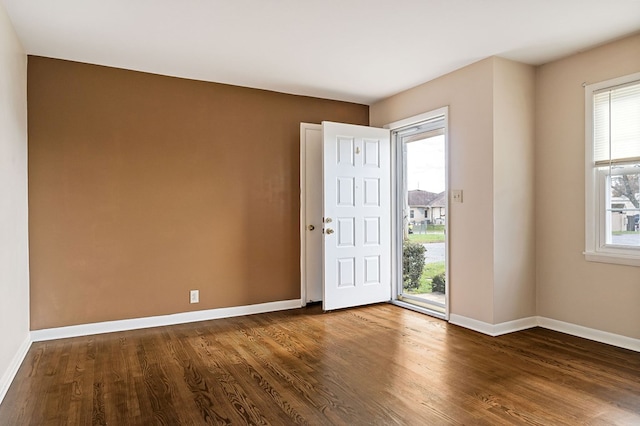 spare room with dark wood-style floors and baseboards