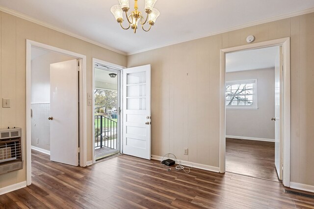 foyer featuring a notable chandelier, crown molding, dark wood finished floors, and heating unit