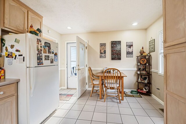 dining room with recessed lighting, a textured ceiling, baseboards, and light tile patterned floors