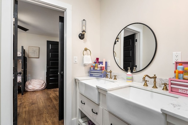 full bathroom with double vanity, wood finished floors, and a sink