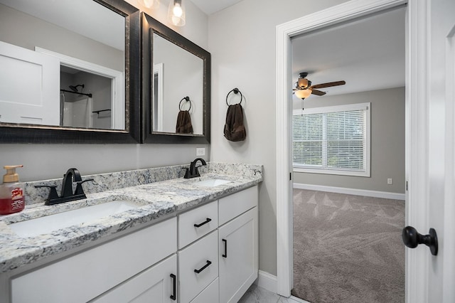 bathroom with double vanity, baseboards, and a sink