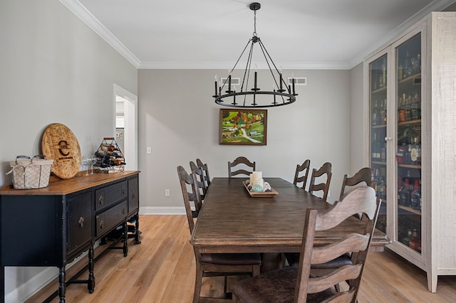 dining area with light wood-style floors, visible vents, and crown molding