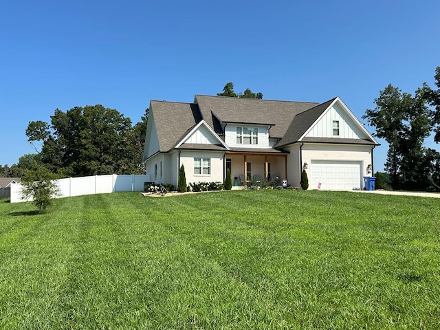 modern farmhouse featuring a garage, fence, board and batten siding, and a front yard