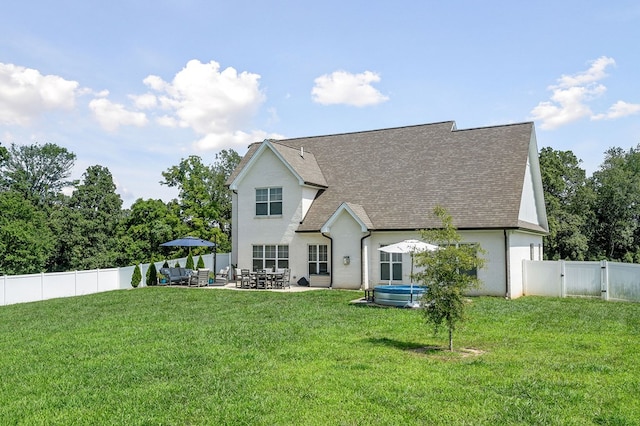 rear view of house with a shingled roof, a patio, a fenced backyard, a gate, and a yard