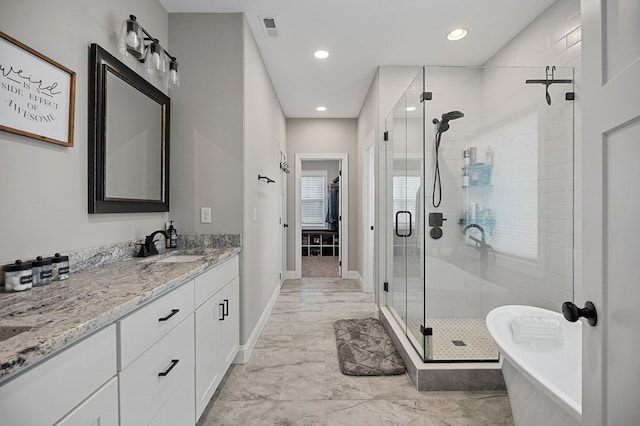 full bath with visible vents, a freestanding bath, a shower stall, vanity, and baseboards