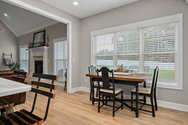 dining space with plenty of natural light, light wood-type flooring, a fireplace, and baseboards