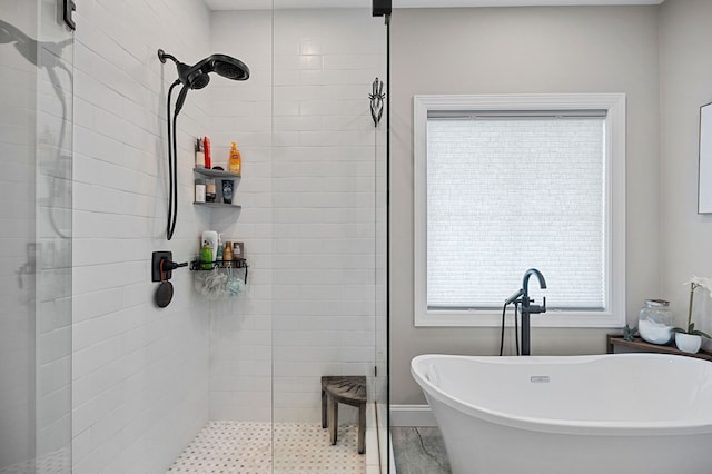 full bath with a soaking tub and tiled shower