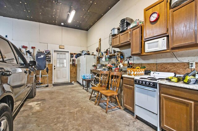 kitchen with light countertops, white appliances, unfinished concrete flooring, and brown cabinets