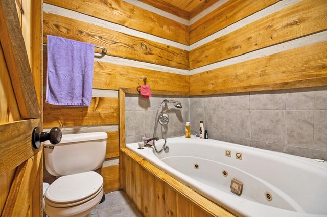 bathroom with a whirlpool tub and toilet