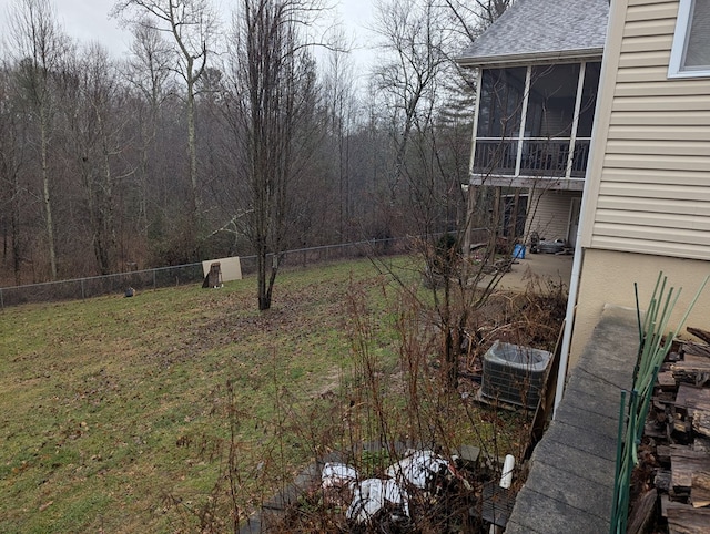 view of yard featuring central AC unit, a sunroom, and fence