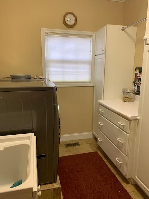 washroom featuring laundry area, baseboards, visible vents, washer / clothes dryer, and light tile patterned flooring