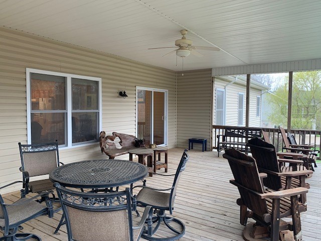 deck with outdoor dining area and a ceiling fan