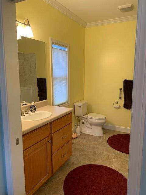 full bath featuring crown molding, toilet, vanity, tile patterned flooring, and baseboards