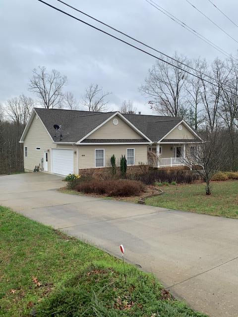 view of front of house featuring concrete driveway, an attached garage, and a front yard