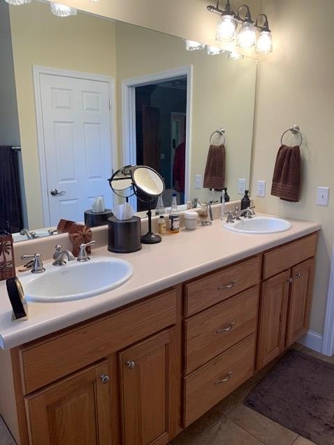 full bathroom featuring double vanity, tile patterned flooring, and a sink