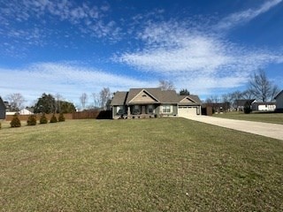 view of front of house with concrete driveway and a front yard