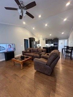 living area with vaulted ceiling, baseboards, a ceiling fan, and crown molding