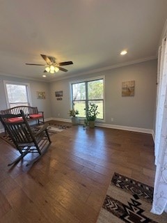 sitting room with baseboards, plenty of natural light, ornamental molding, and wood finished floors