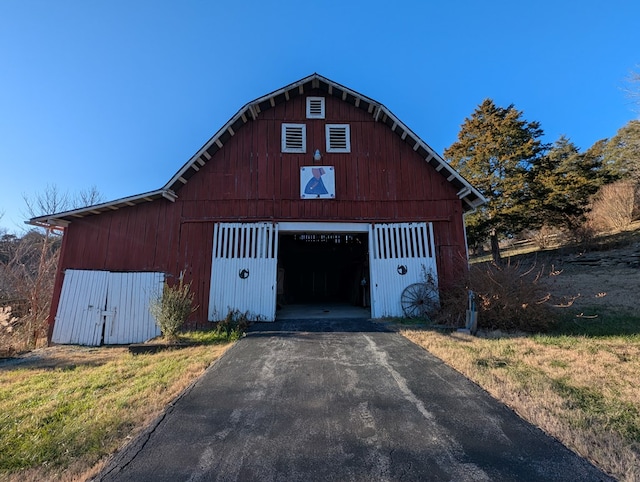 garage with driveway and a detached garage