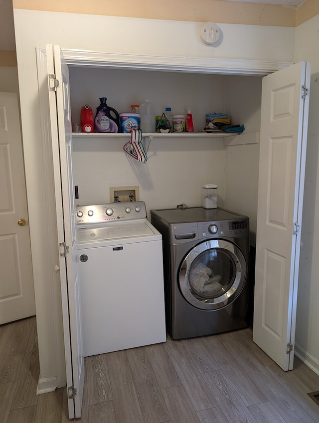 clothes washing area featuring laundry area, light wood-type flooring, visible vents, and washer and dryer