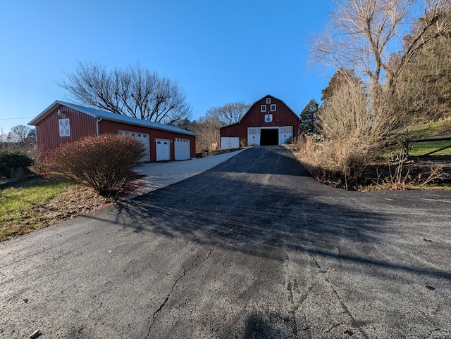 view of front of property featuring an outbuilding, a detached garage, and a barn