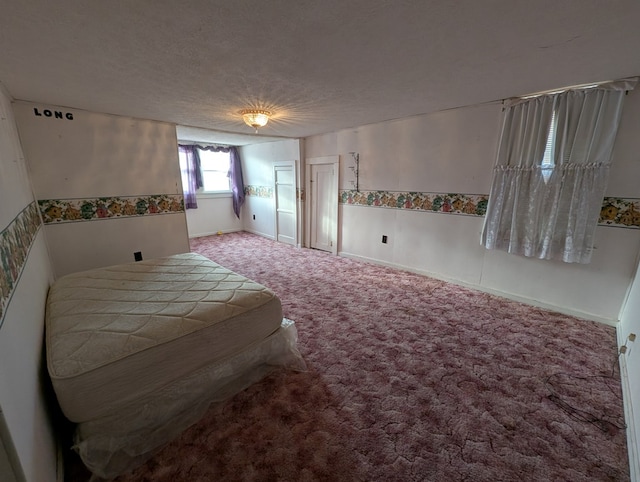 bedroom featuring a textured ceiling, carpet flooring, and baseboards