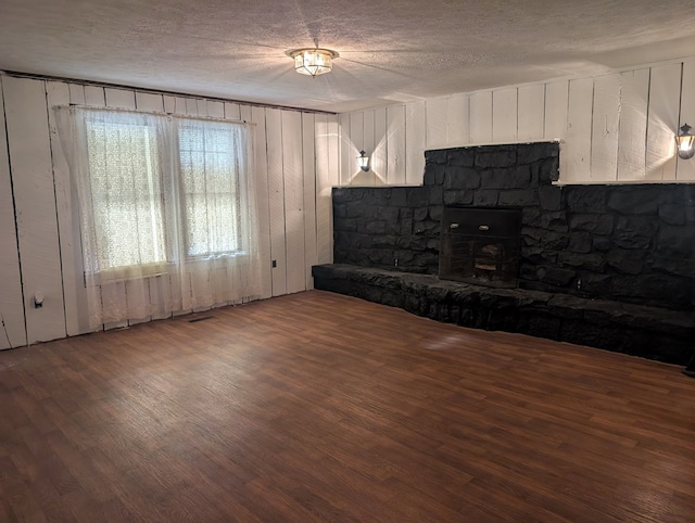 unfurnished living room featuring a textured ceiling and dark wood-type flooring