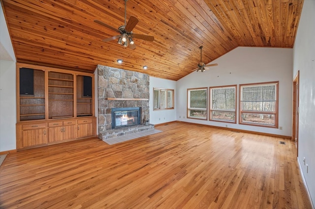 unfurnished living room featuring a ceiling fan, a stone fireplace, light wood finished floors, baseboards, and wood ceiling