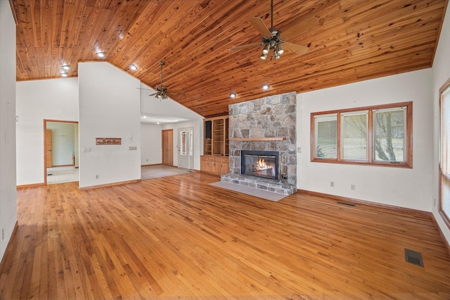 unfurnished living room with a stone fireplace, wood ceiling, hardwood / wood-style floors, and ceiling fan